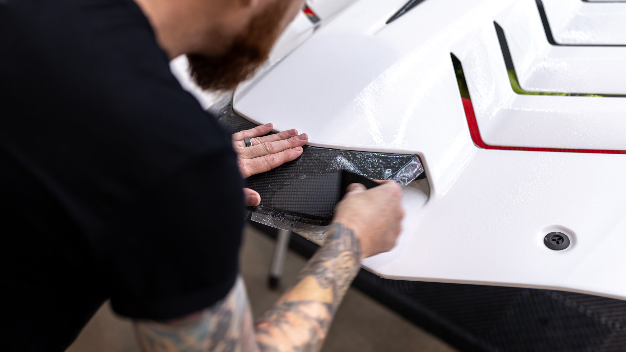 Applying XPEL Stealth PPF to the carbon fiber roof scoop on the engine cover of this Lamborghini Huracan STO